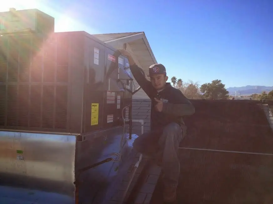 HVAC technician performing AC Tune-Up on a rooftop unit in O'Fallon